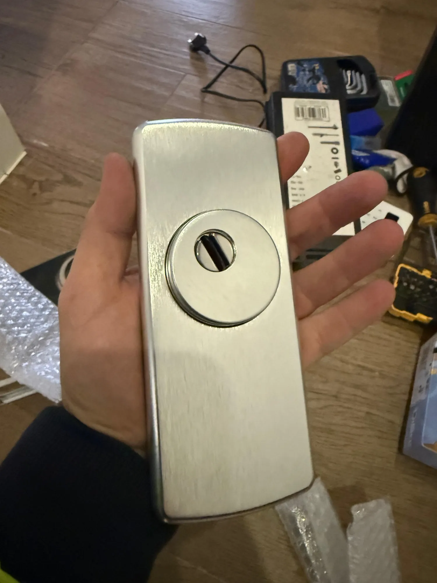 Escudo de seguridad de acero satinado con disco protector, recién sacado del embalaje, en la mano de uno de nuestros técnicos en Villaviciosa de Odón.