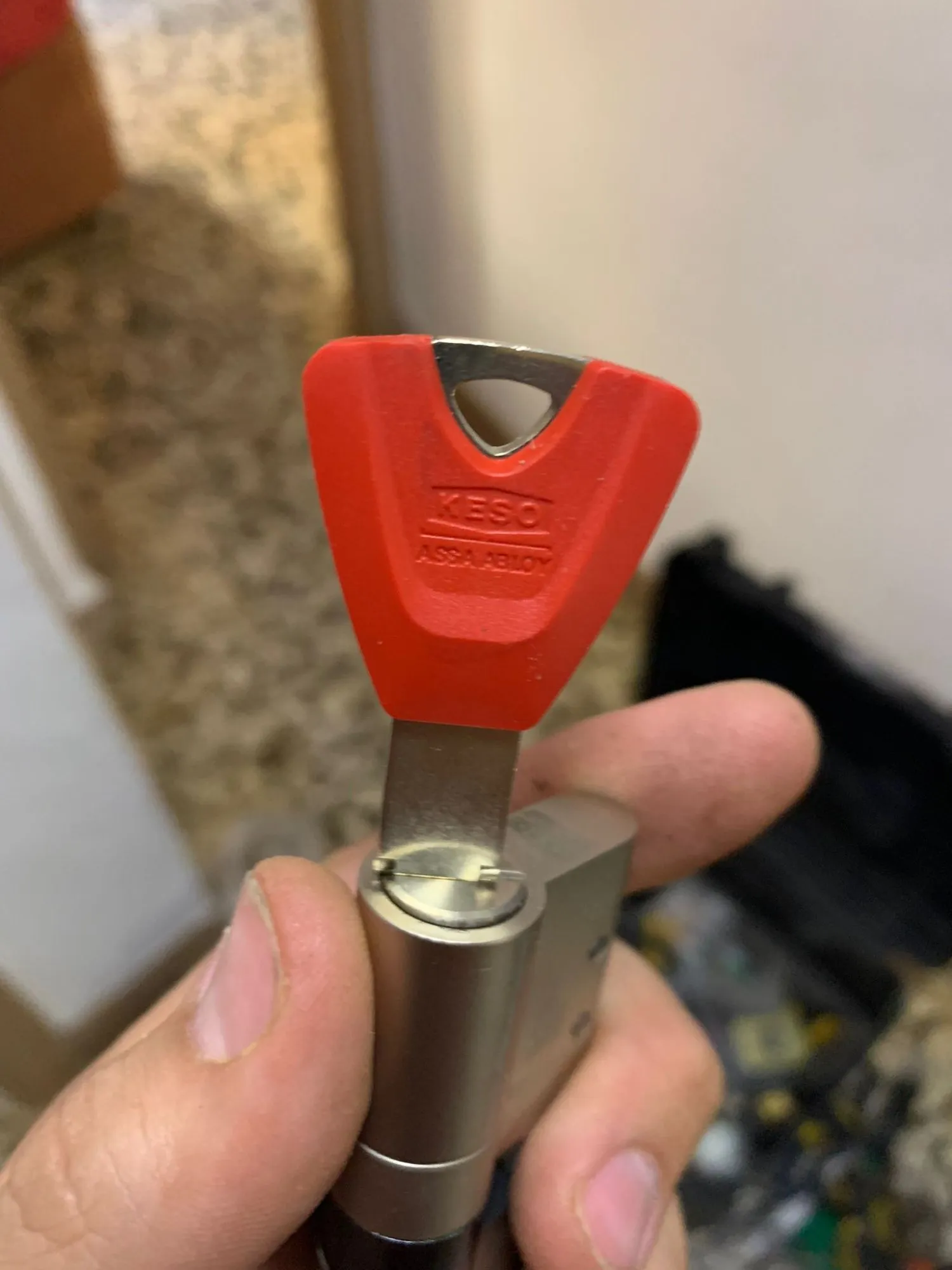 Llave de seguridad Keso, de Assa Abloy, con la cabeza roja y metida en su bombín, en un trabajo en Coslada.